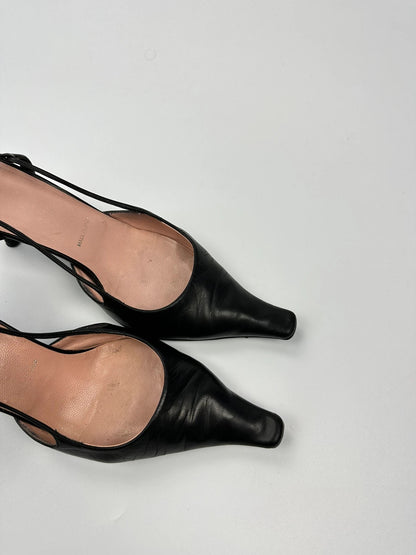 Prada black leather slingback mules with minimalist design and logo detail.