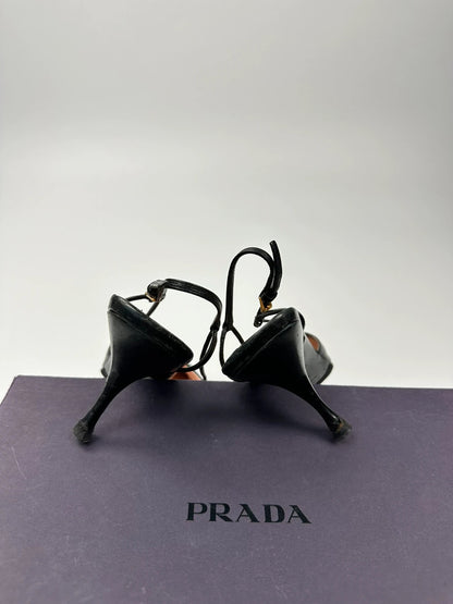 Prada black leather slingback mules with minimalist design and logo detail.