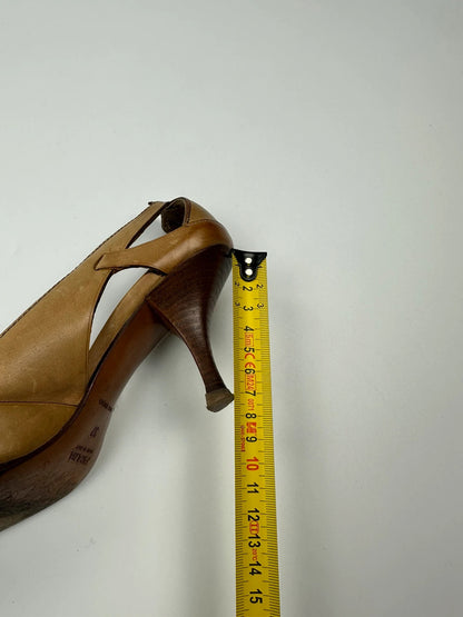 Prada beige leather pumps with pointy toe and subtle logo detailing.