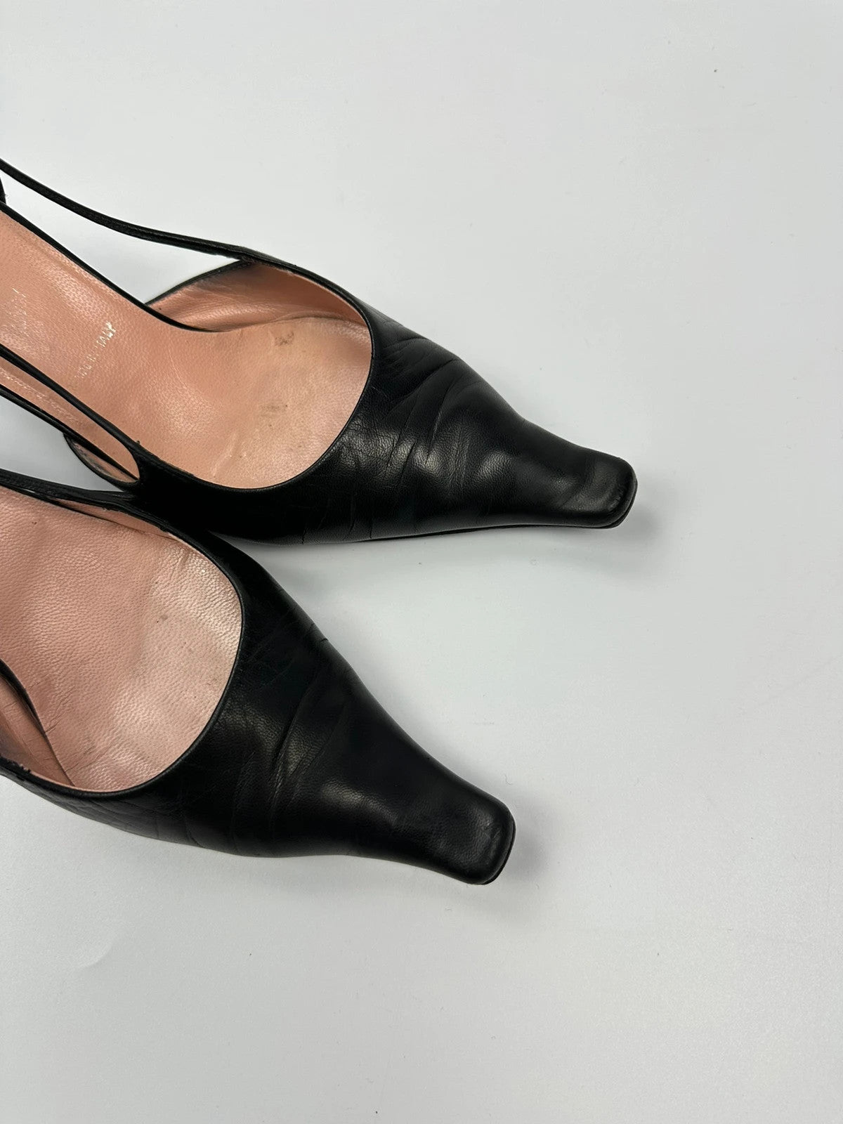 Prada black leather slingback mules with minimalist design and logo detail.
