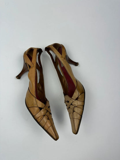 Prada beige leather pumps with pointy toe and subtle logo detailing.