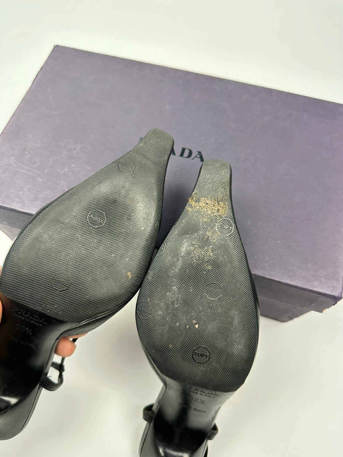 Prada black leather slingback mules with minimalist design and logo detail.