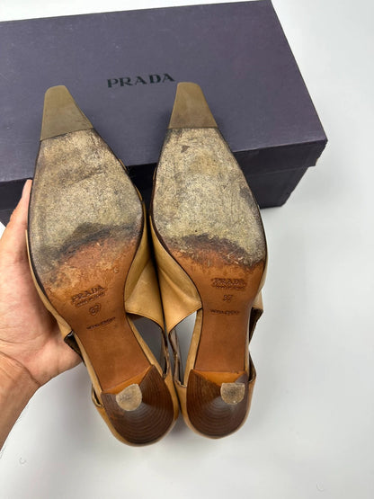 Prada beige leather pumps with pointy toe and subtle logo detailing.