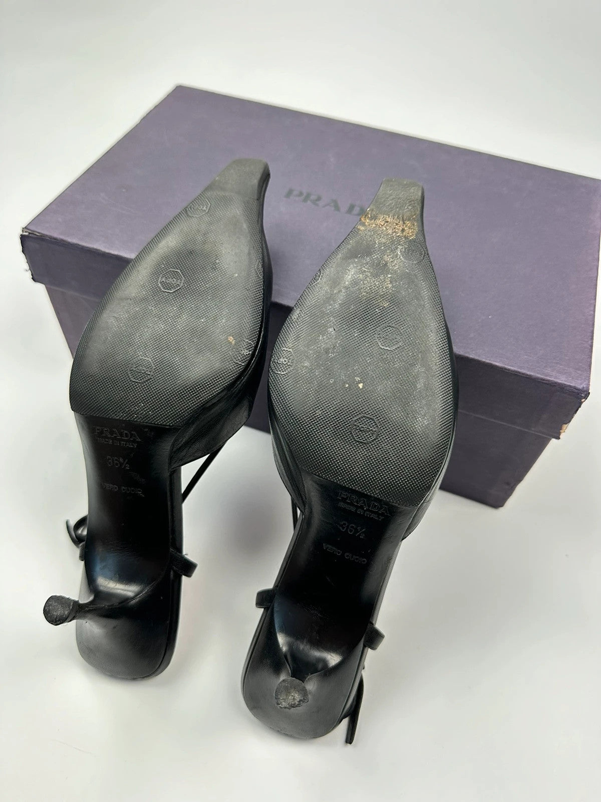 Prada black leather slingback mules with minimalist design and logo detail.