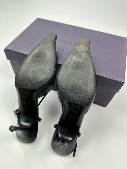 Prada black leather slingback mules with minimalist design and logo detail.