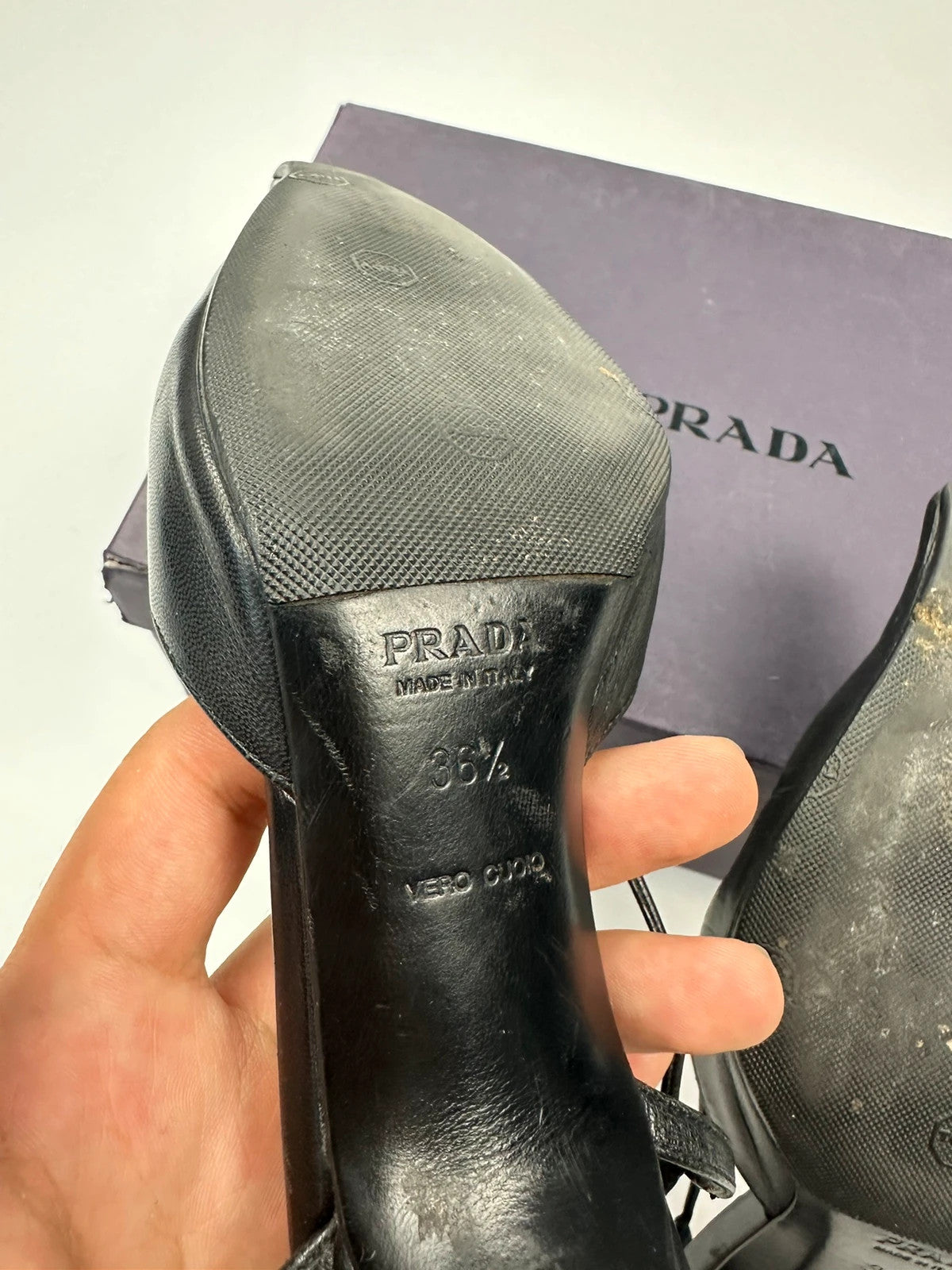 Prada black leather slingback mules with minimalist design and logo detail.
