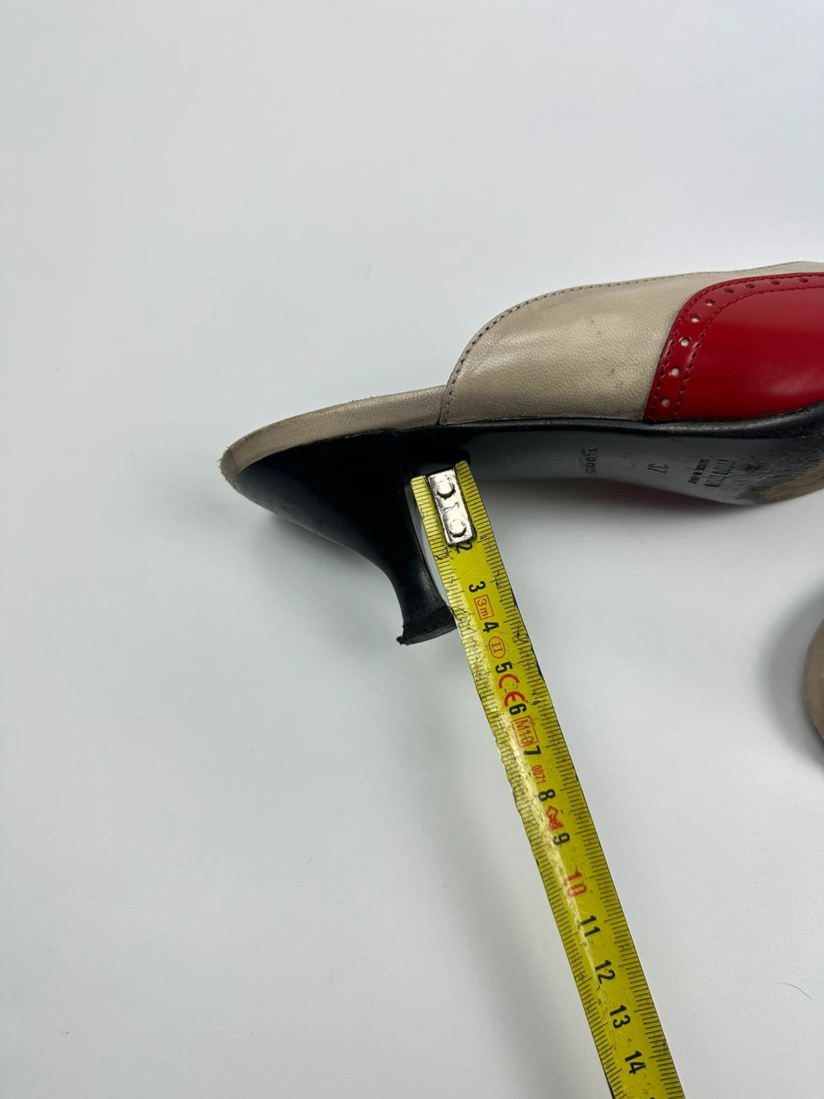Miu Miu beige and red leather mules with kitten heels and minimalist design.