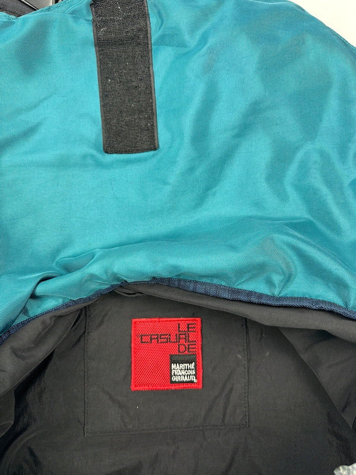 Marithé François Girbaud red and black messenger bag with mesh pocket and logo details.