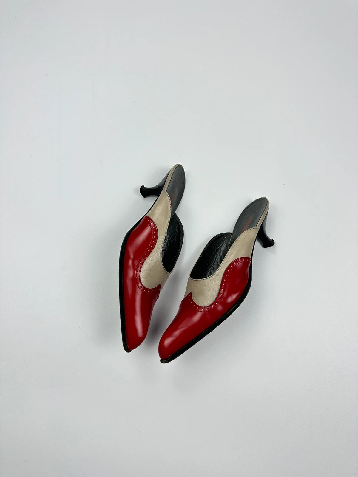 Miu Miu beige and red leather mules with kitten heels and minimalist design.