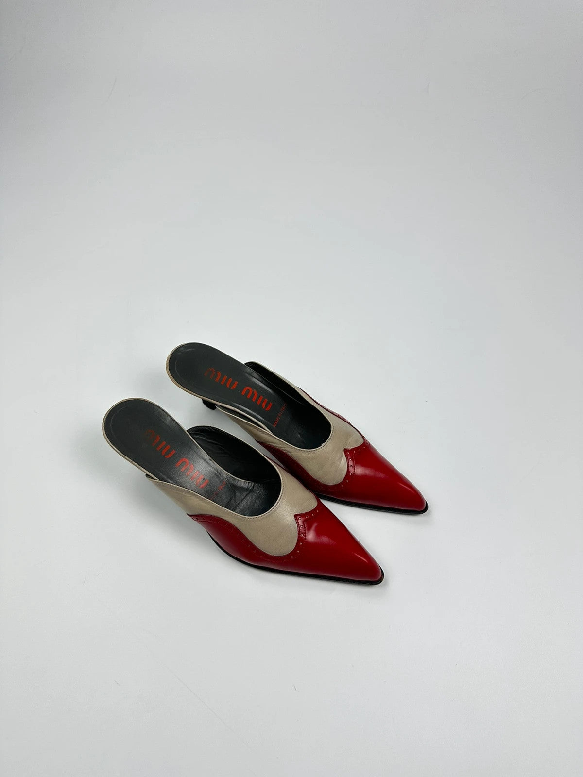 Miu Miu beige and red leather mules with kitten heels and minimalist design.