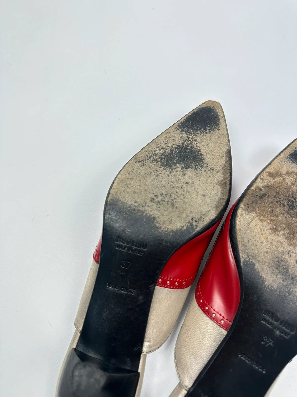 Miu Miu beige and red leather mules with kitten heels and minimalist design.