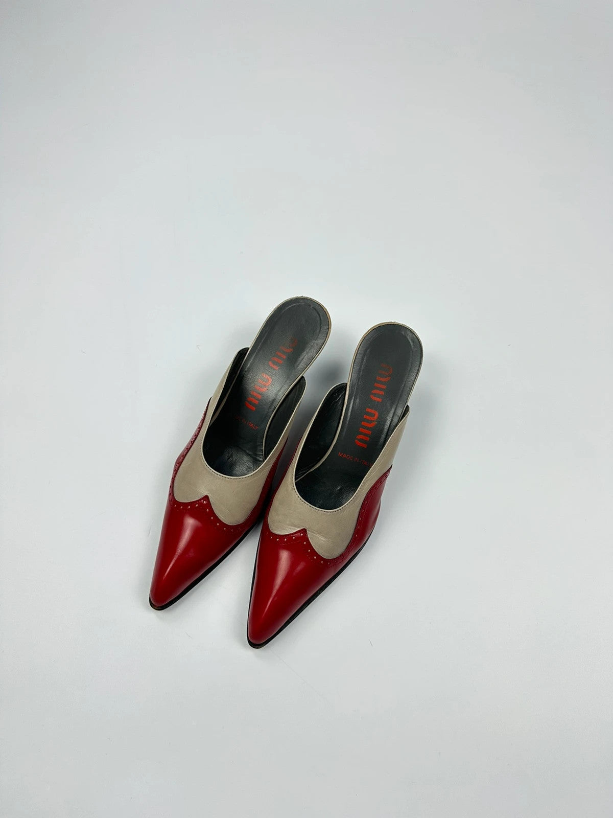 Miu Miu beige and red leather mules with kitten heels and minimalist design.