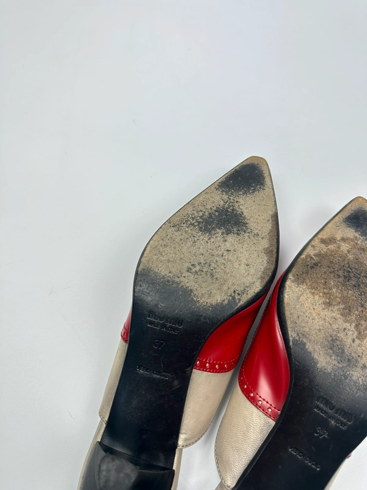 Miu Miu beige and red leather mules with kitten heels and minimalist design.