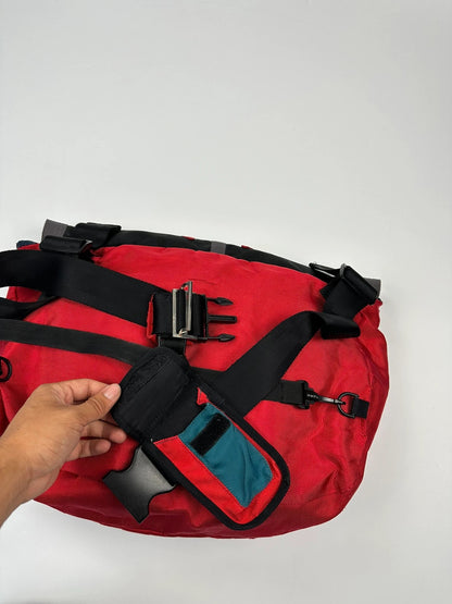 Marithé François Girbaud red and black messenger bag with mesh pocket and logo details.