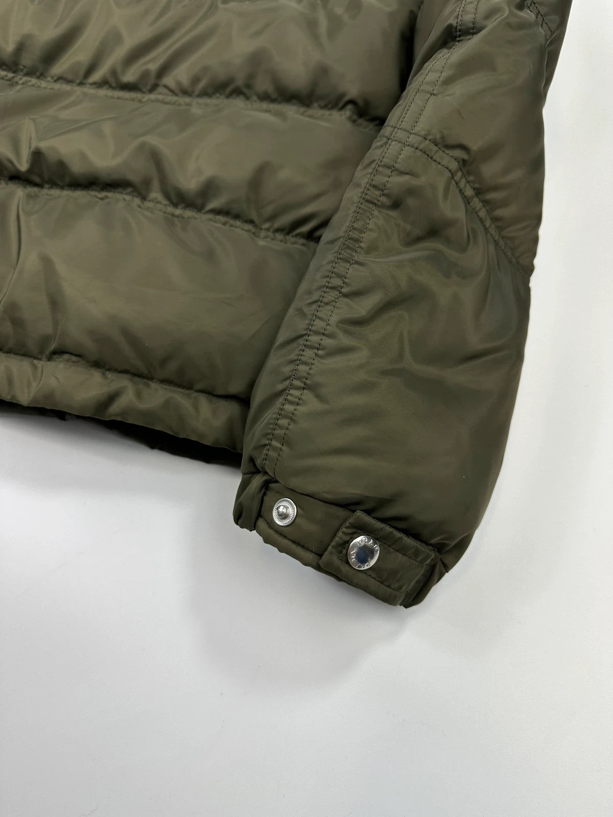 Prada khaki puffer down jacket with hood, featuring triangle logo and luxurious material.