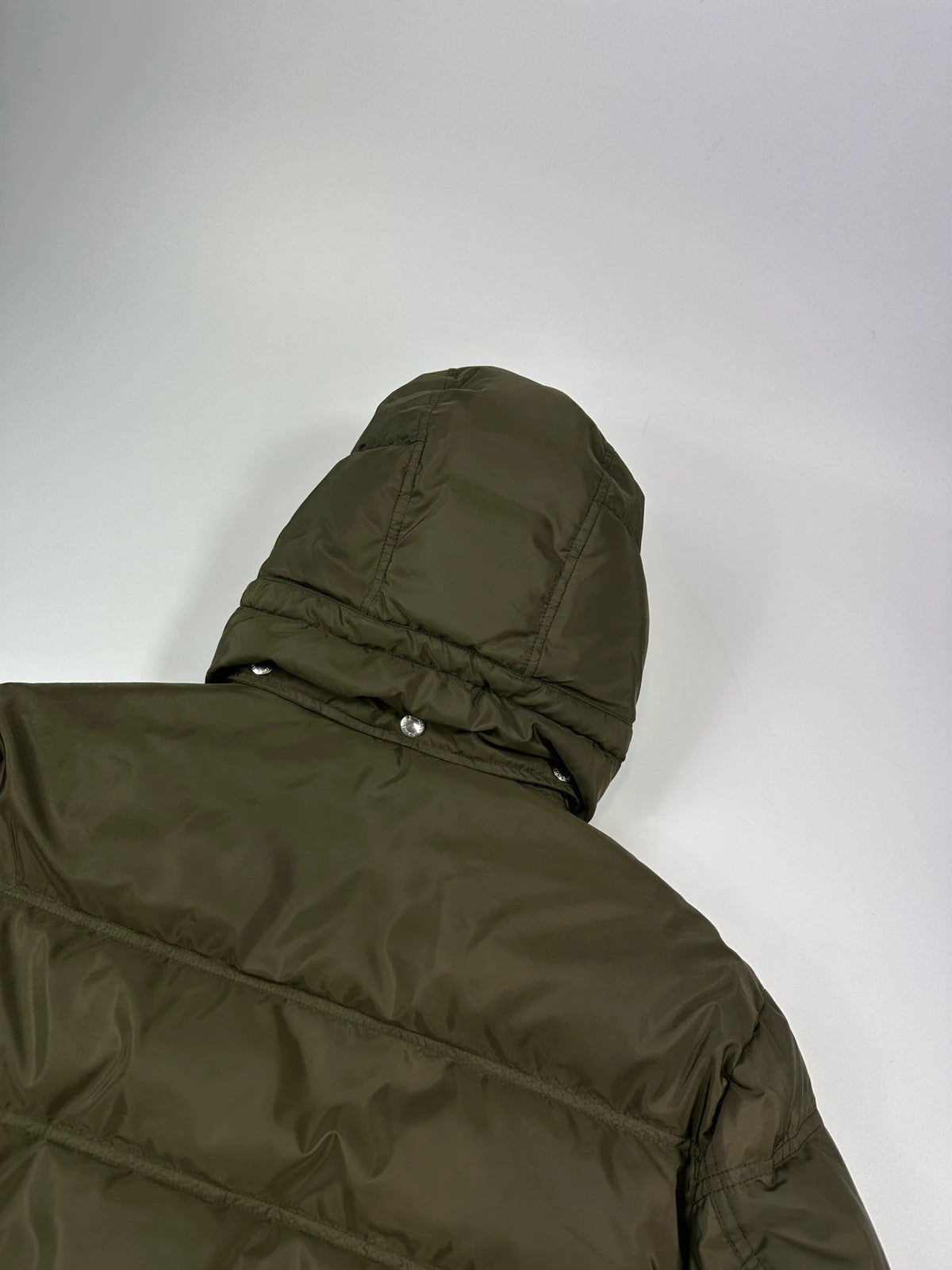 Prada khaki puffer down jacket with hood, featuring triangle logo and luxurious material.