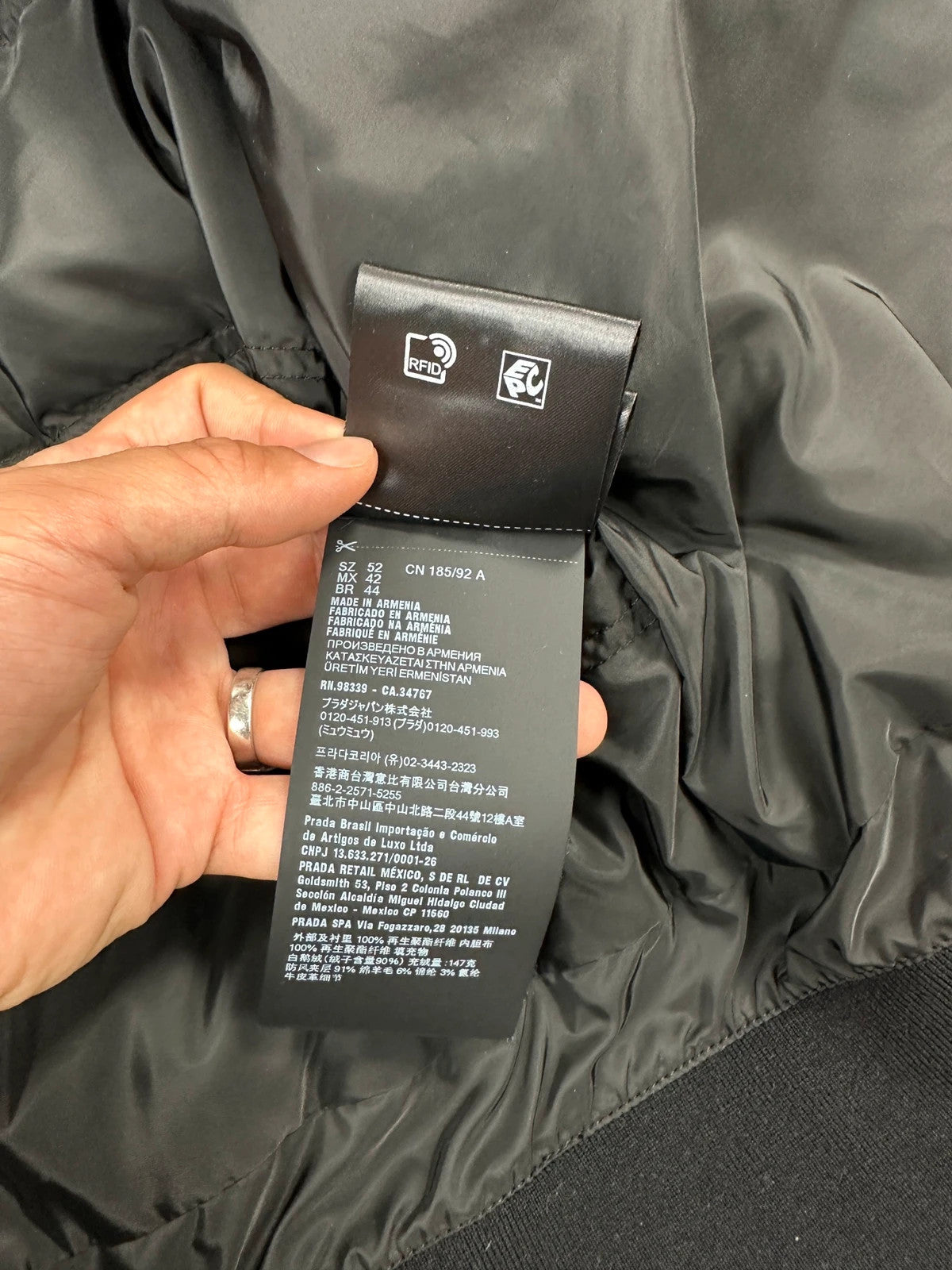 Prada khaki puffer down jacket with hood, featuring triangle logo and luxurious material.