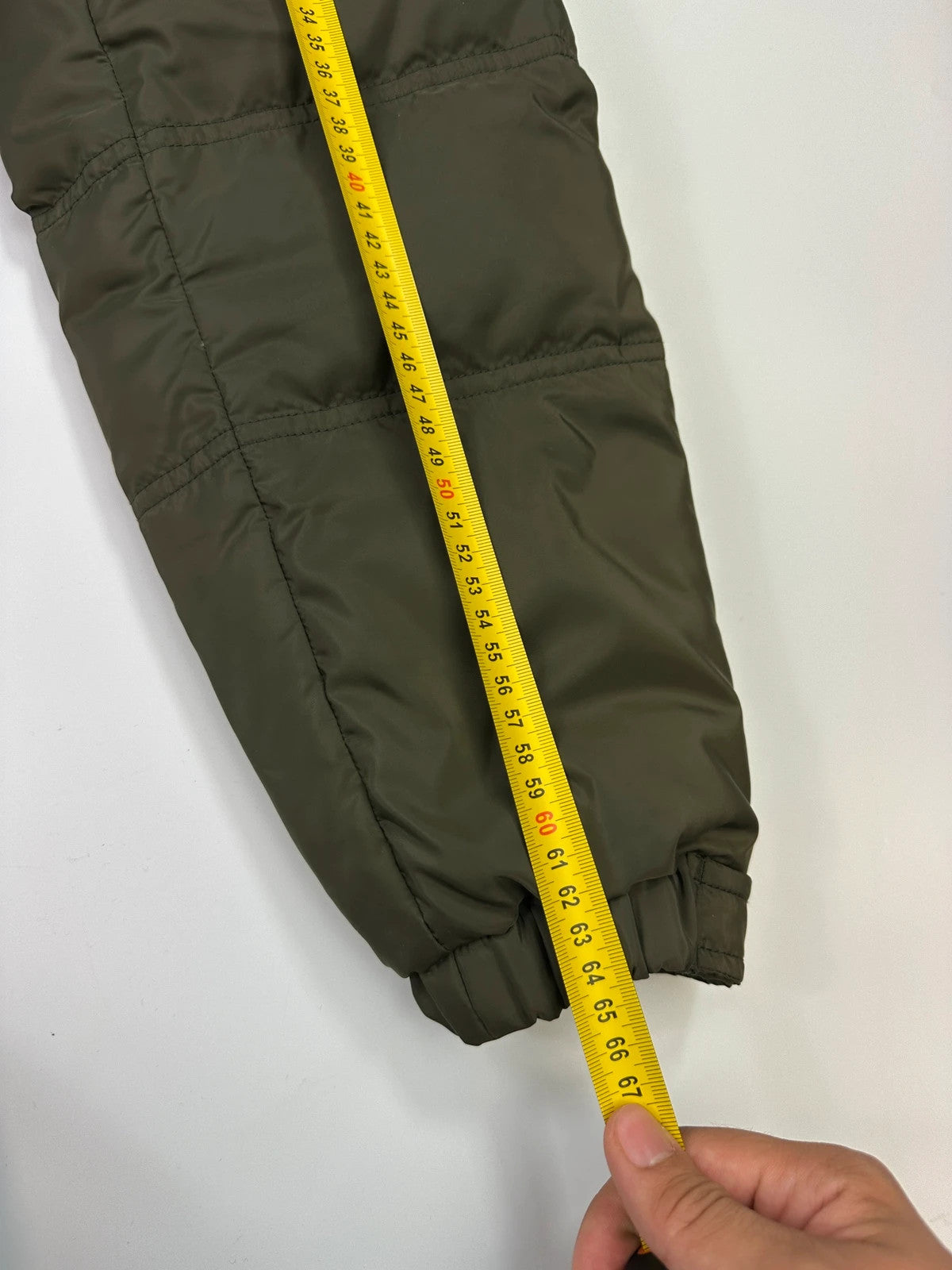 Prada khaki puffer down jacket with hood, featuring triangle logo and luxurious material.