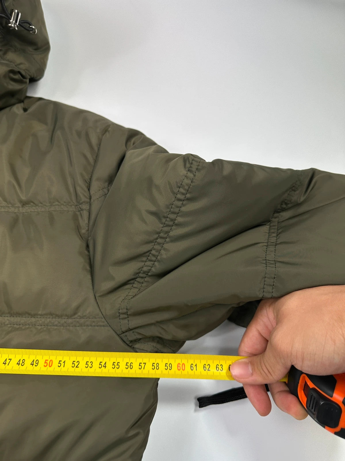 Prada khaki puffer down jacket with hood, featuring triangle logo and luxurious material.