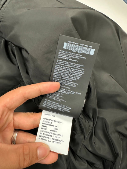 Prada khaki puffer down jacket with hood, featuring triangle logo and luxurious material.