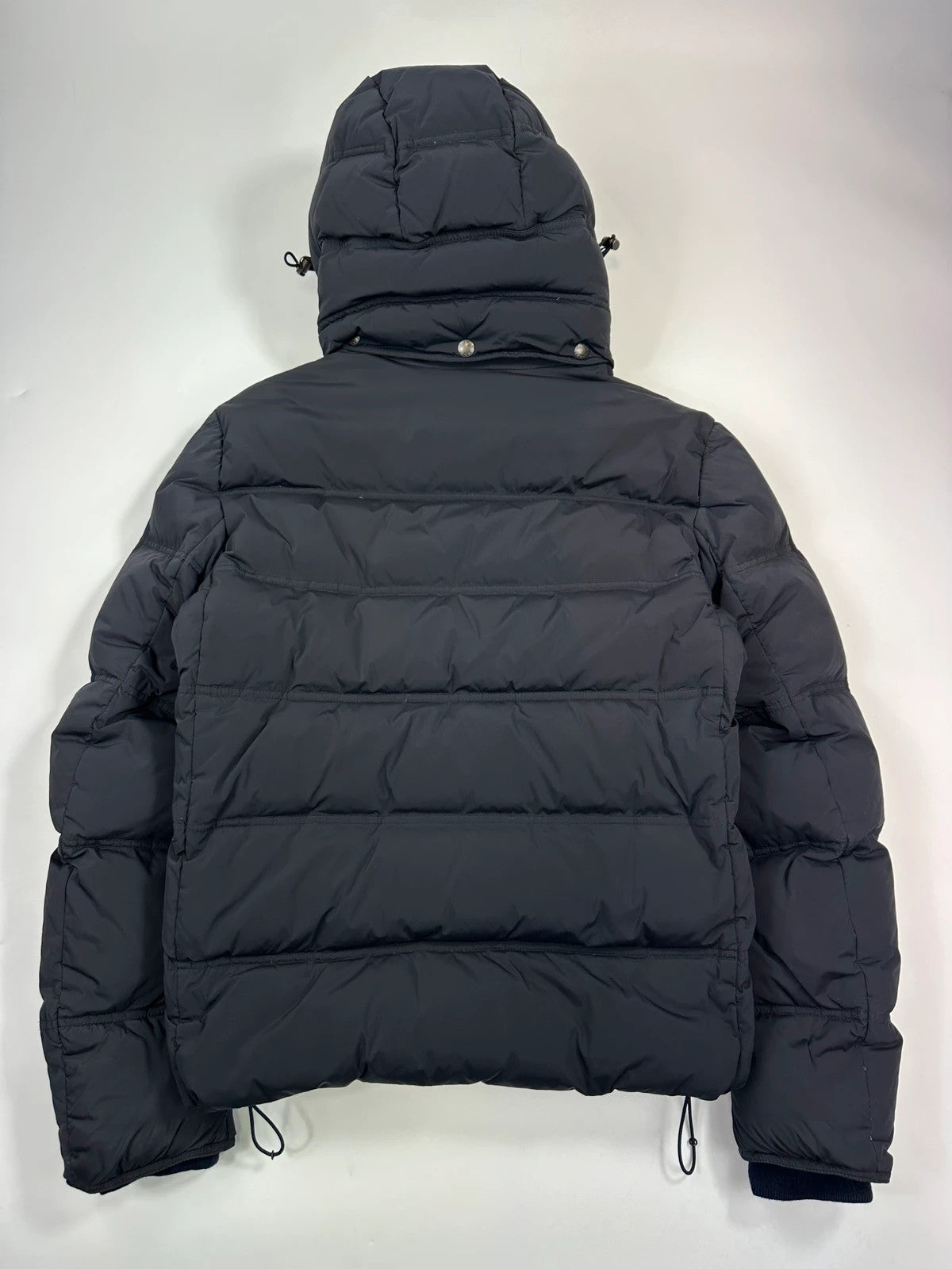Prada dark navy hooded puffer jacket with triangle logo and vintage 2000s design.