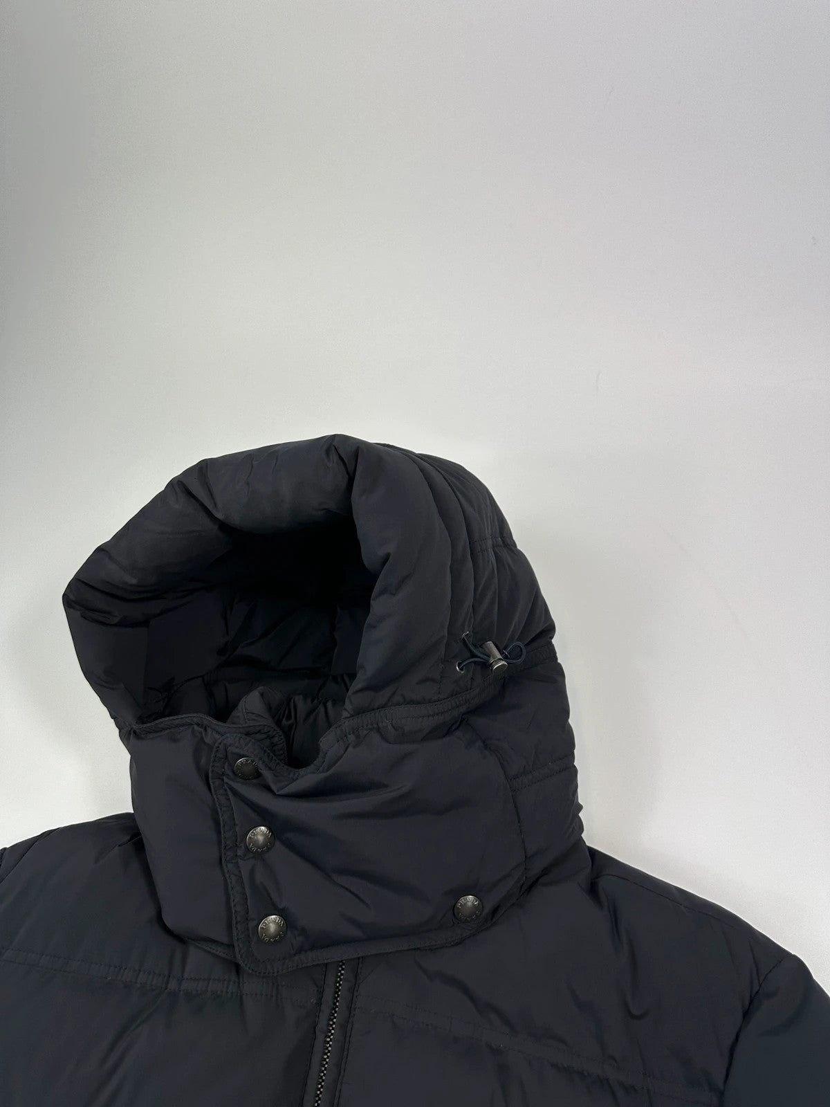 Prada dark navy hooded puffer jacket with triangle logo and vintage 2000s design.