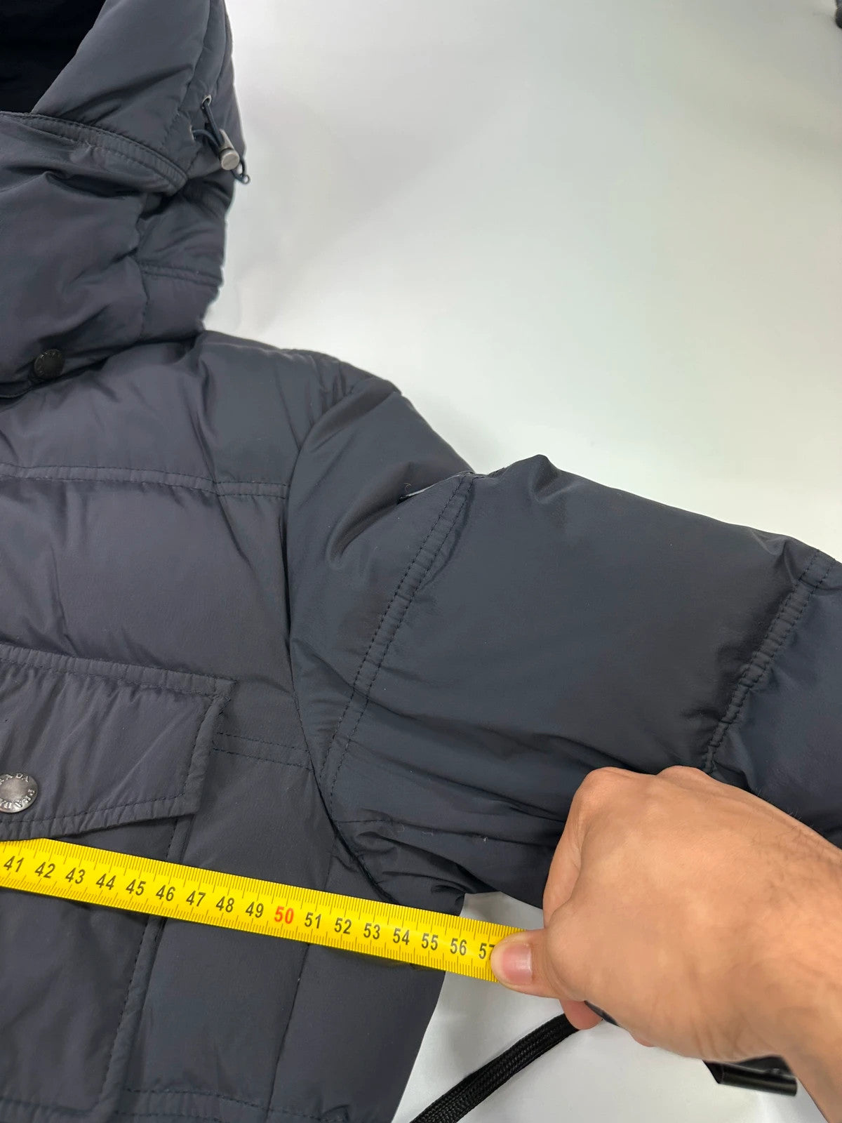 Prada dark navy hooded puffer jacket with triangle logo and vintage 2000s design.