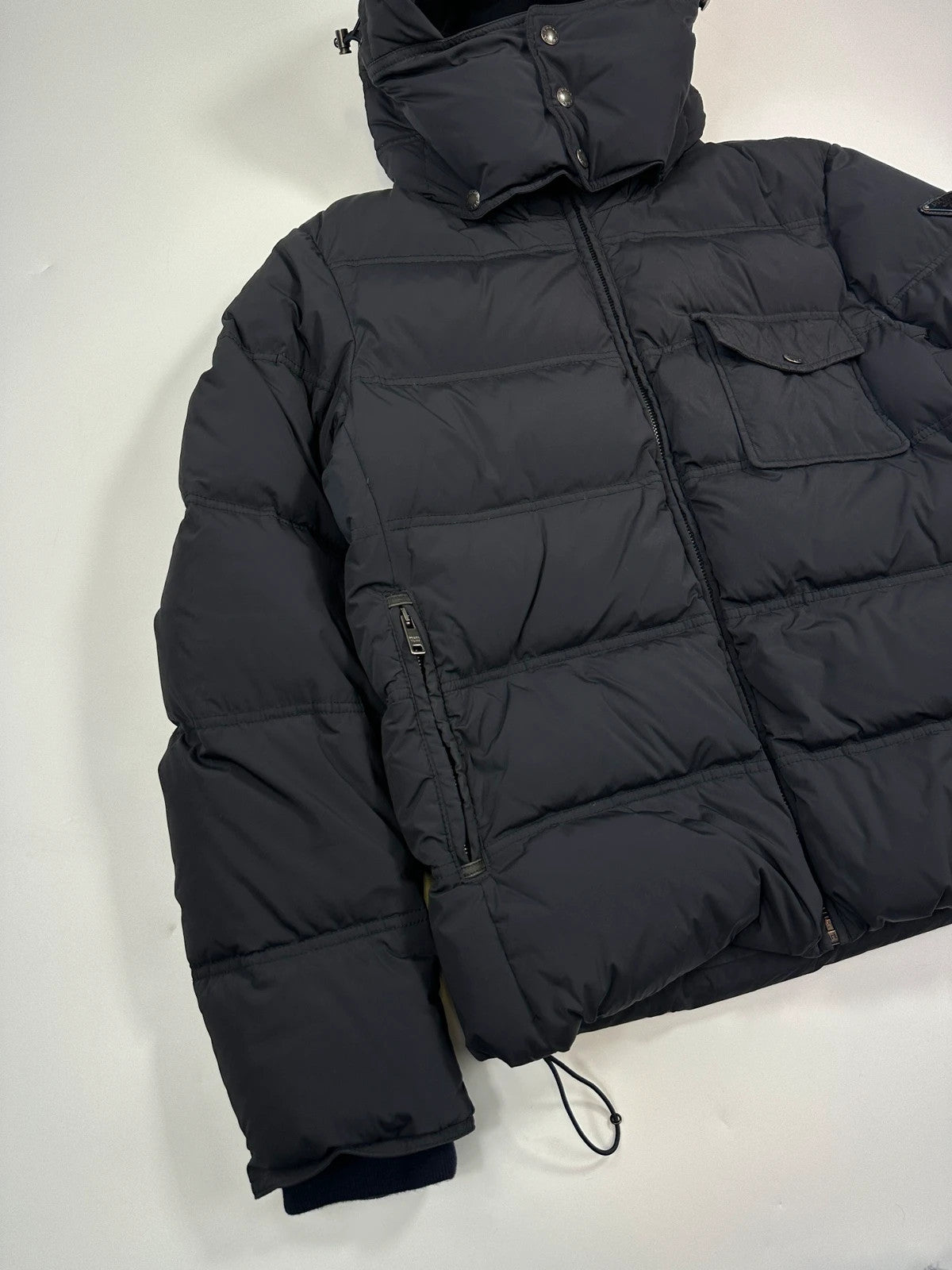 Prada dark navy hooded puffer jacket with triangle logo and vintage 2000s design.