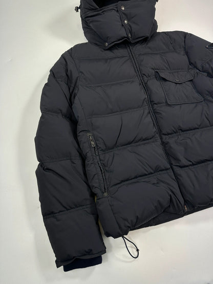 Prada dark navy hooded puffer jacket with triangle logo and vintage 2000s design.