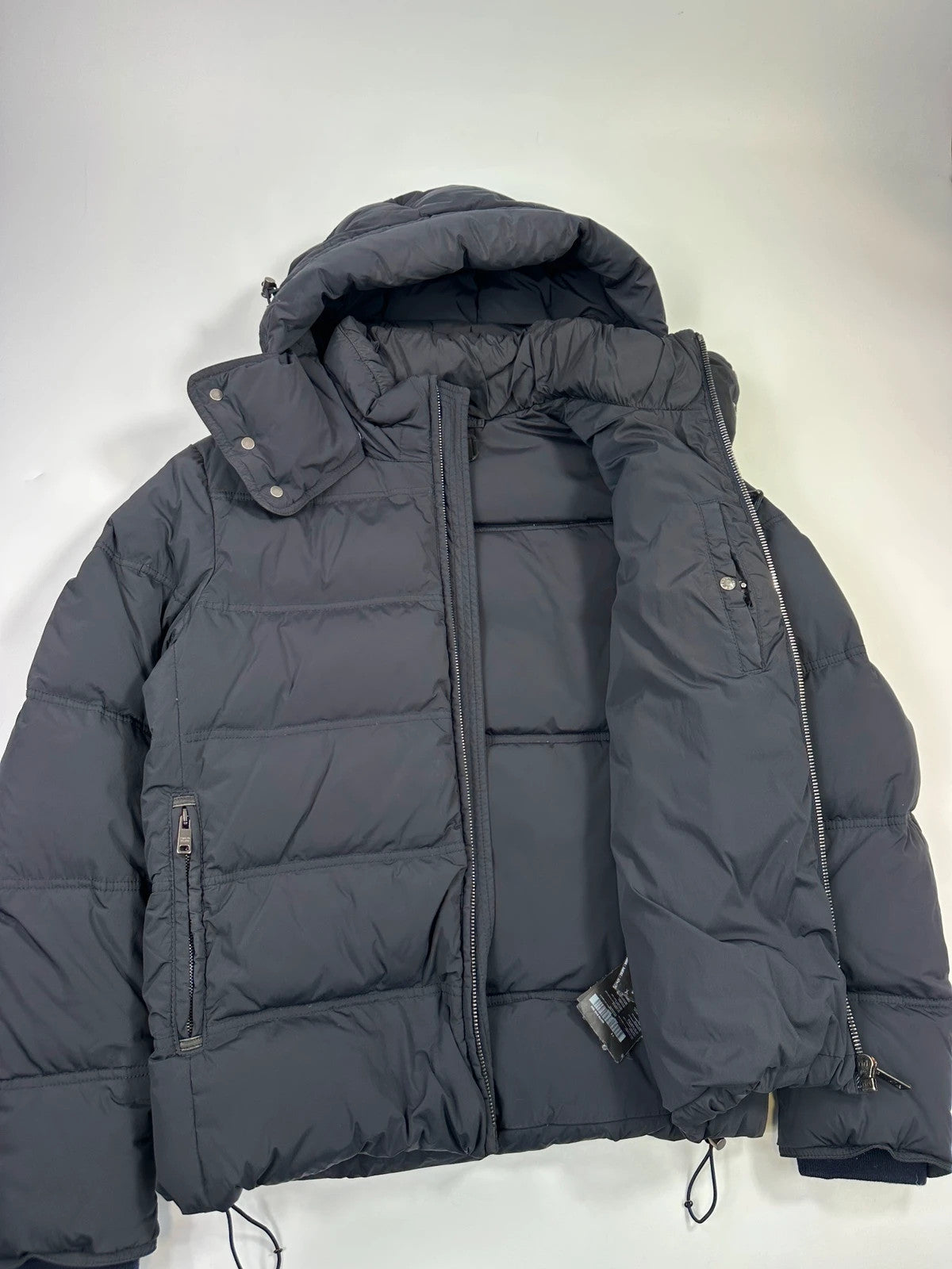 Prada dark navy hooded puffer jacket with triangle logo and vintage 2000s design.