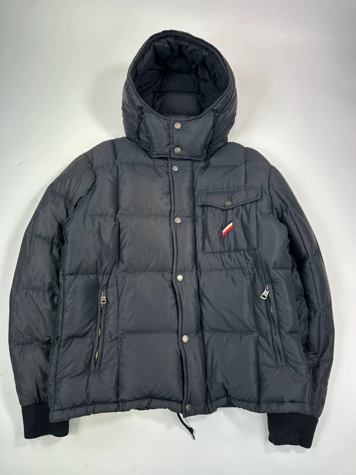 Moncler navy blue puffer jacket with French logo and hood, down-filled material.