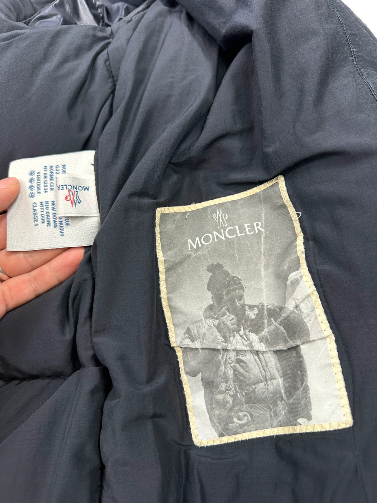 Moncler navy blue puffer jacket with French logo and hood, down-filled material.