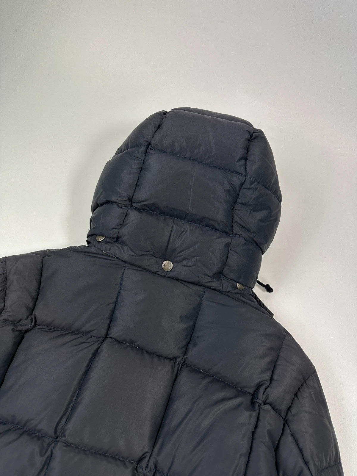 Moncler navy blue puffer jacket with French logo and hood, down-filled material.