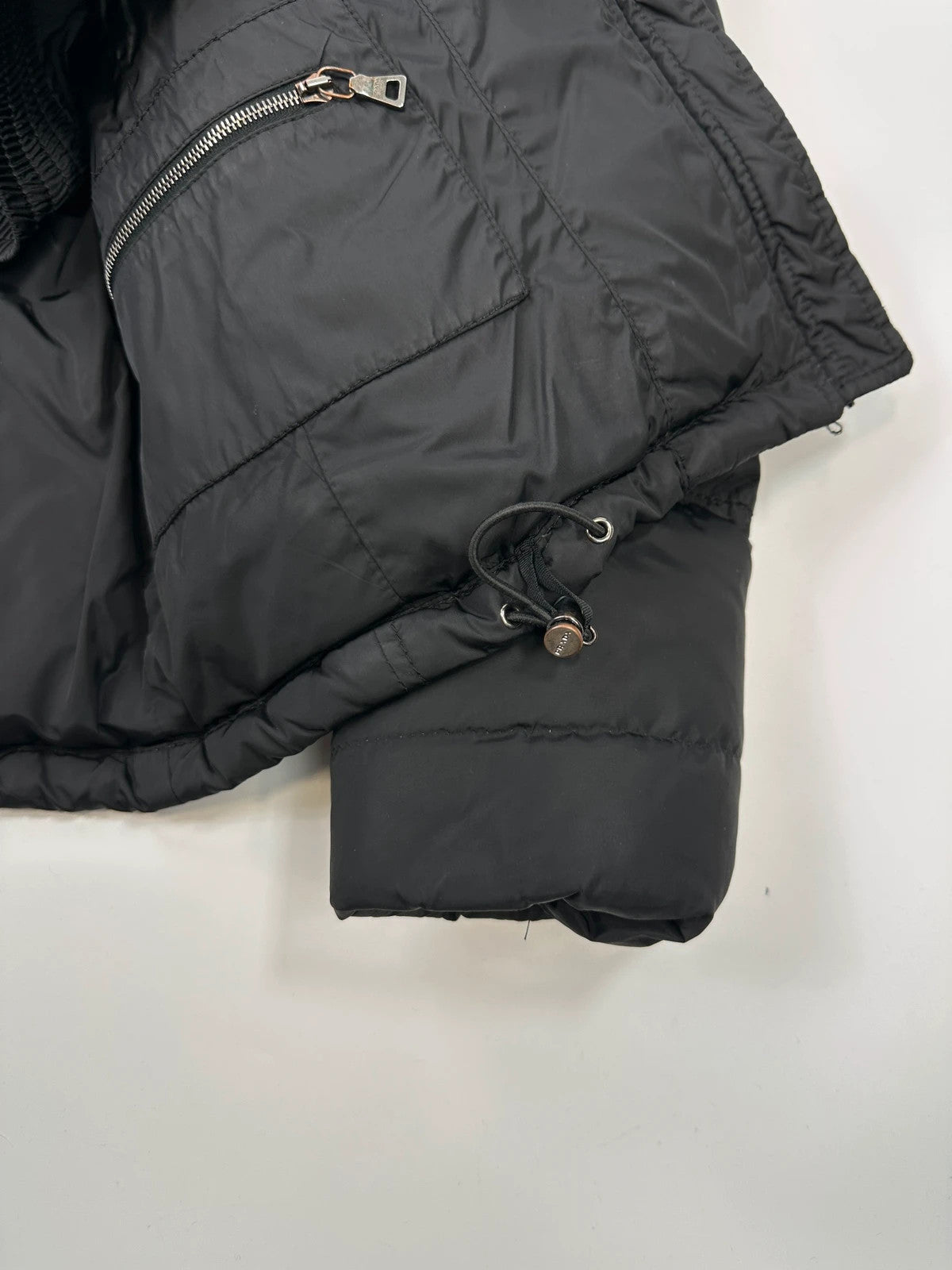 Prada black fitted nylon down puffer jacket with hood and logo detail.
