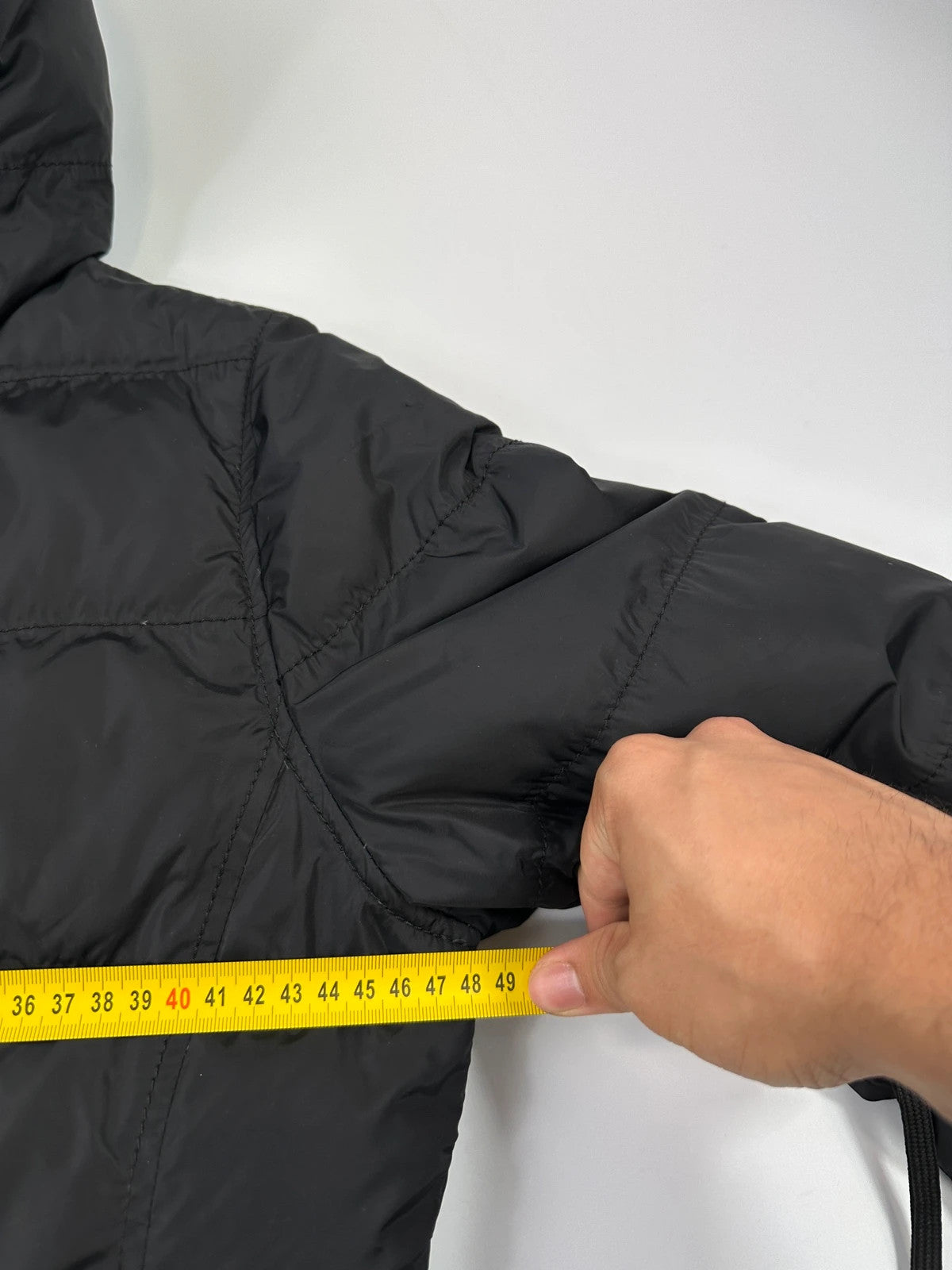 Prada black fitted nylon down puffer jacket with hood and logo detail.