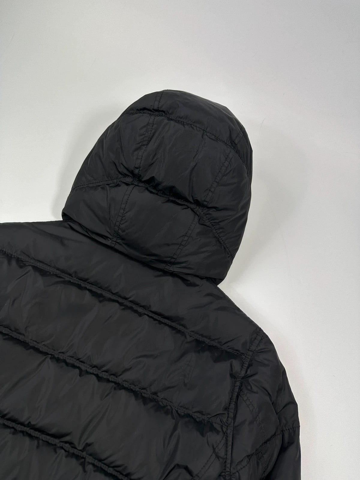 Prada black fitted nylon down puffer jacket with hood and logo detail.