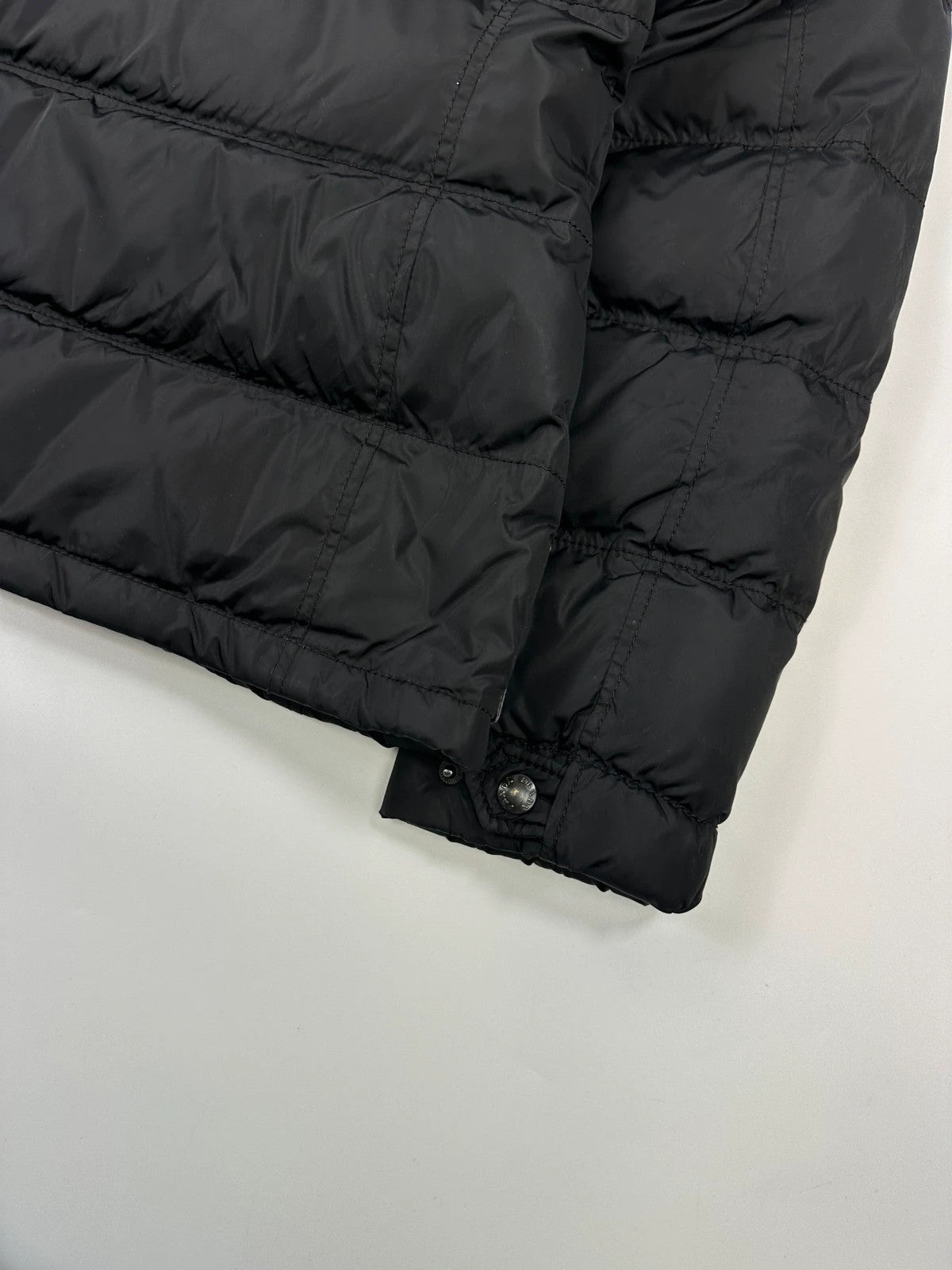 Prada black fitted nylon down puffer jacket with hood and logo detail.