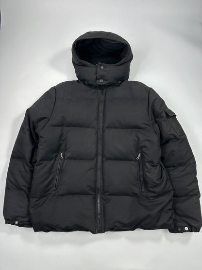 Moncler black hooded puffer jacket with logo patch and quilted down detailing.