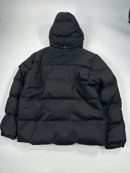 Moncler black hooded puffer jacket with logo patch and quilted down detailing.