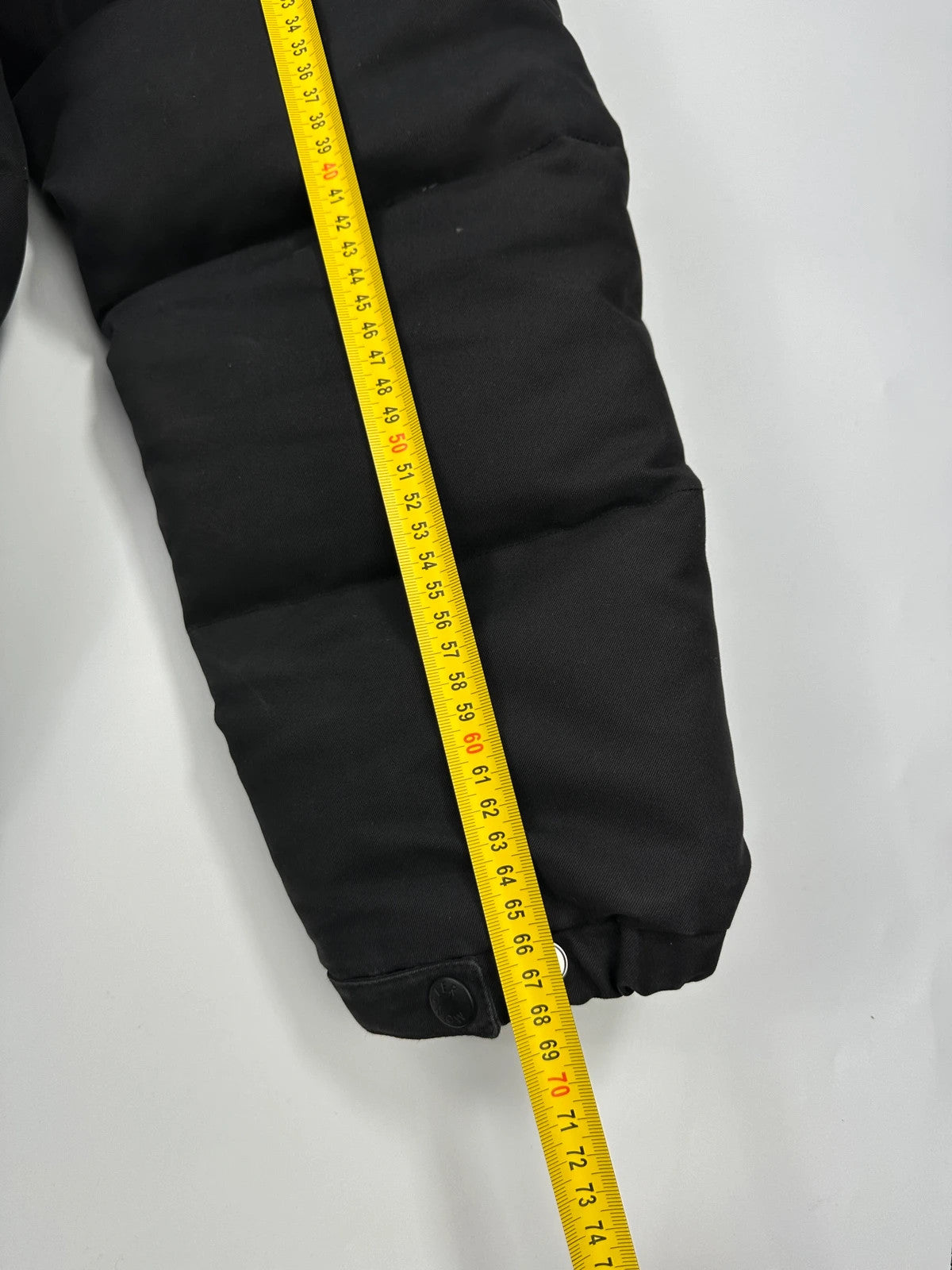 Moncler black hooded puffer jacket with logo patch and quilted down detailing.