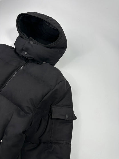 Moncler black hooded puffer jacket with logo patch and quilted down detailing.