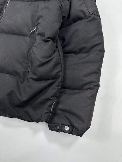 Moncler black hooded puffer jacket with logo patch and quilted down detailing.