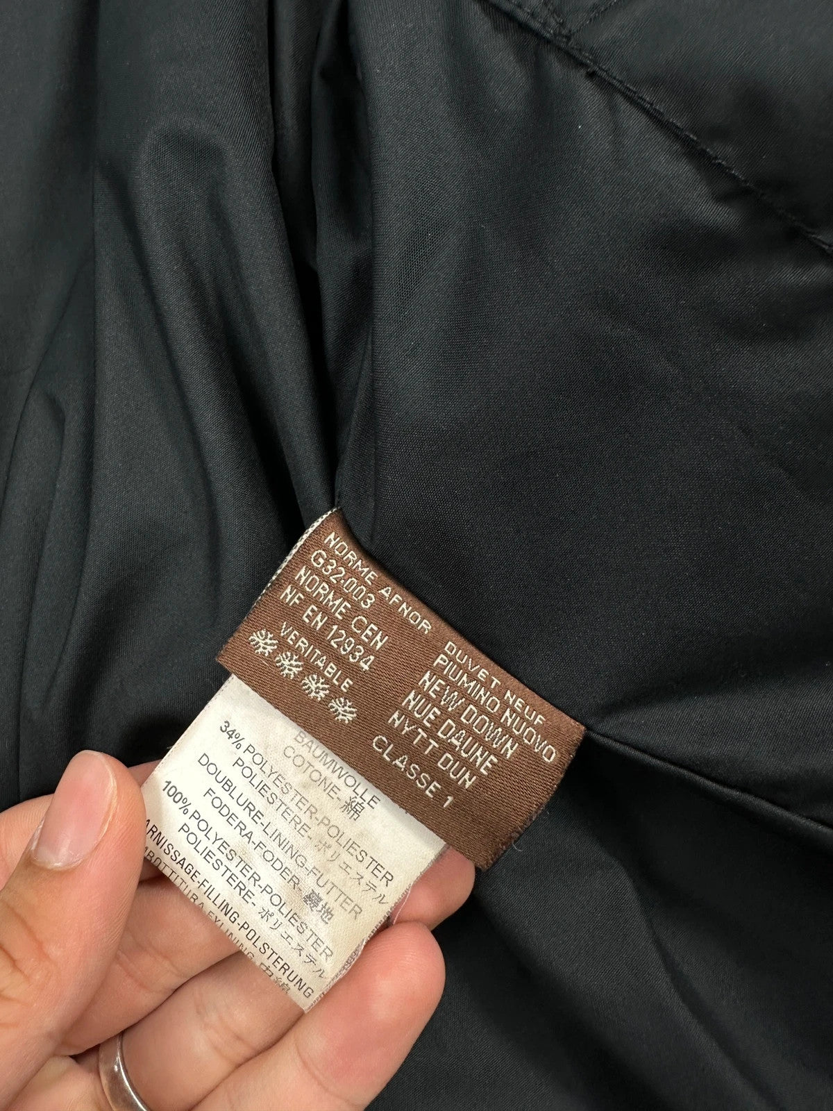 Moncler black hooded puffer jacket with logo patch and quilted down detailing.
