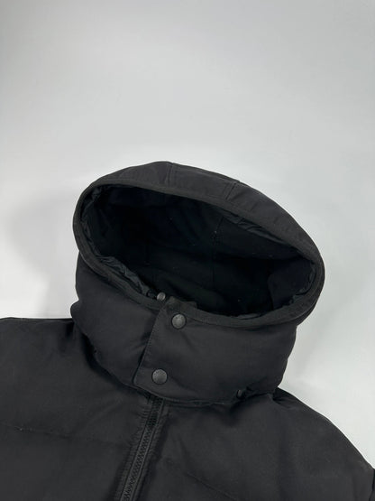 Moncler black hooded puffer jacket with logo patch and quilted down detailing.