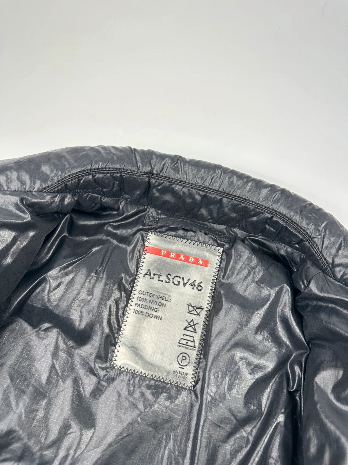 Prada black puffer jacket with shirt collar and Ripstop nylon fabric.