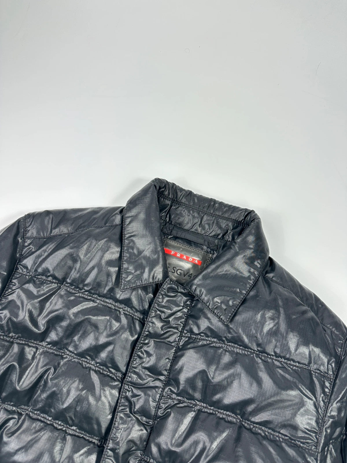 Prada black puffer jacket with shirt collar and Ripstop nylon fabric.
