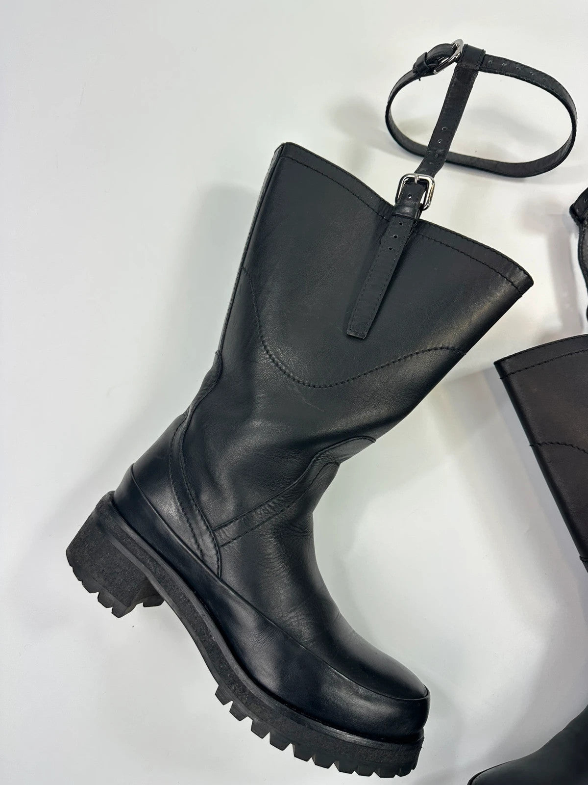 Prada black leather garter strap boots with minimalist design and original box.