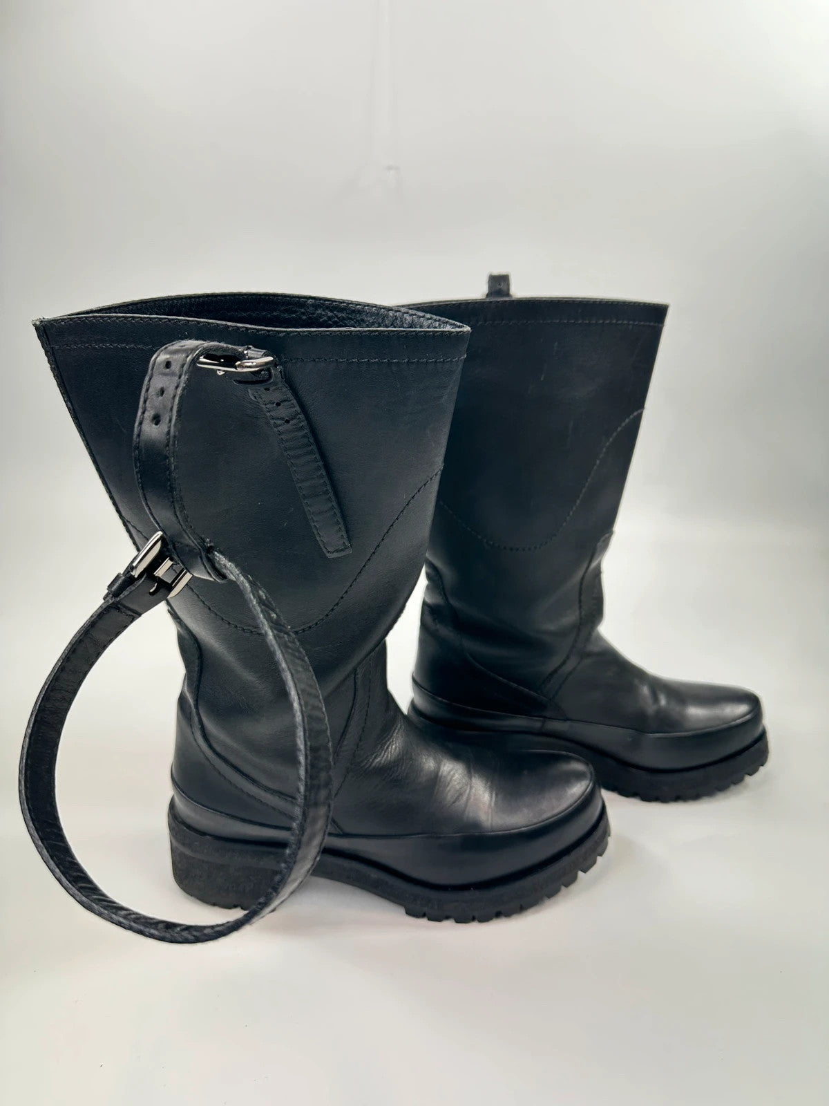 Prada black leather garter strap boots with minimalist design and original box.