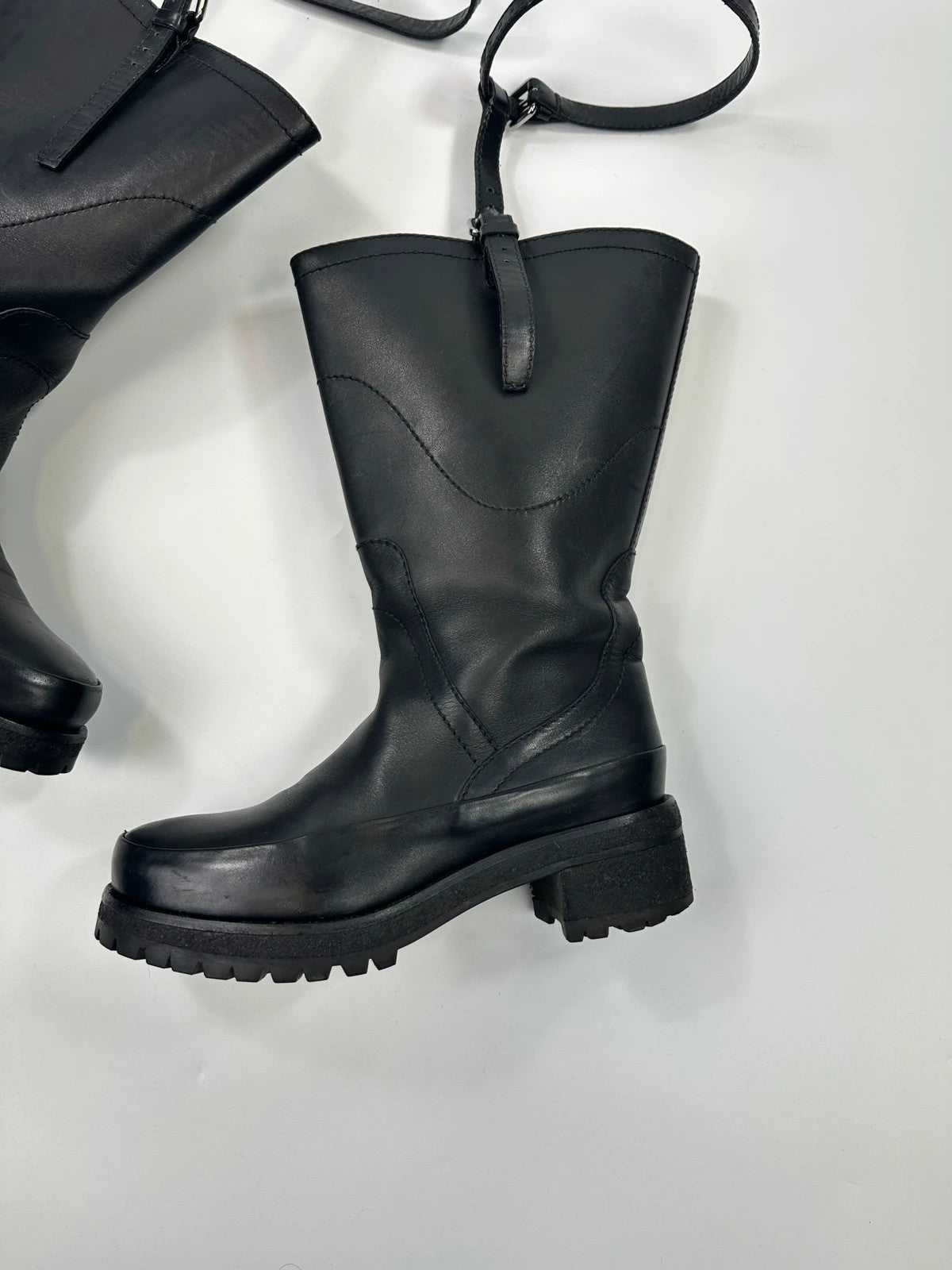 Prada black leather garter strap boots with minimalist design and original box.