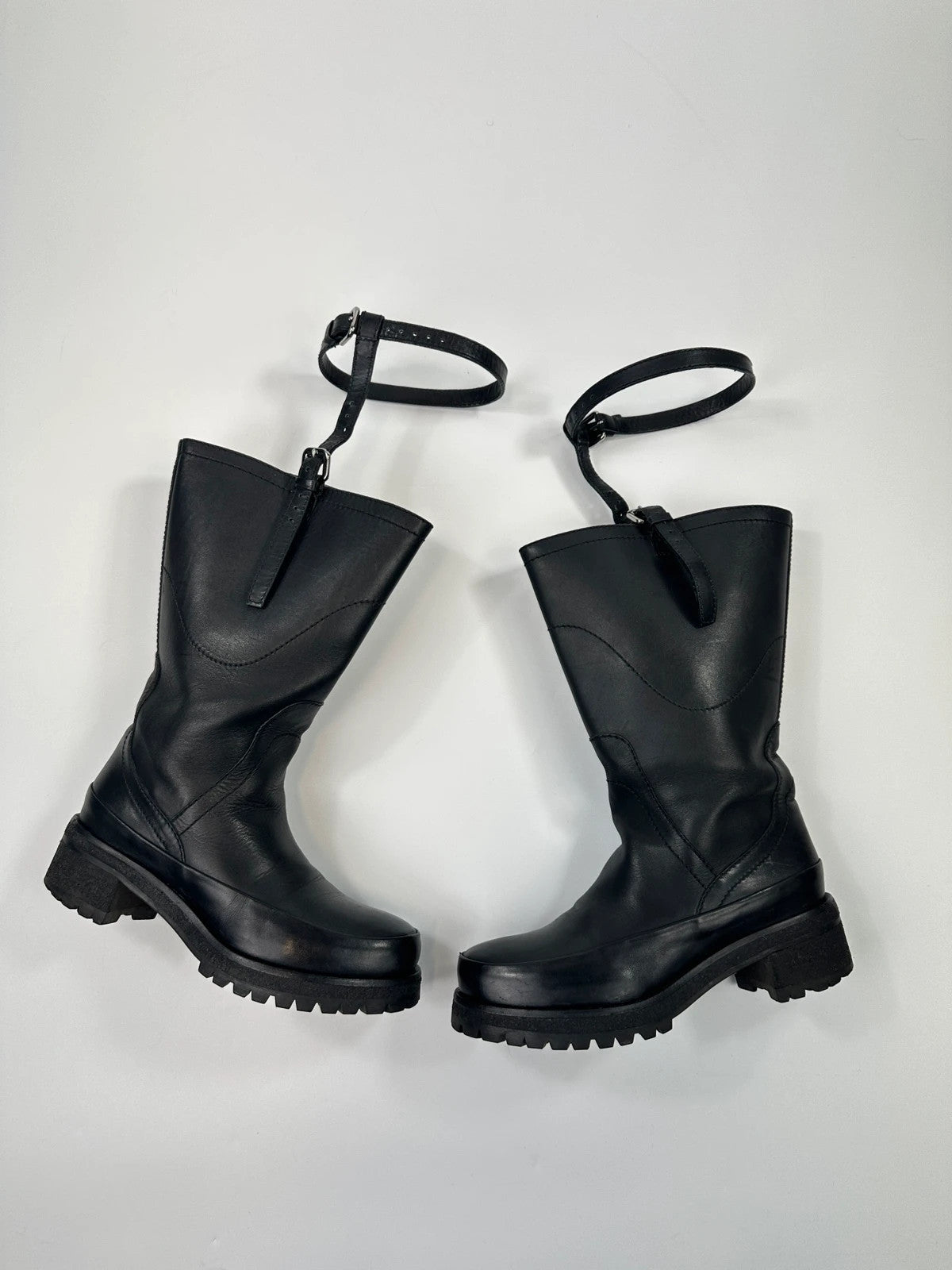Prada black leather garter strap boots with minimalist design and original box.